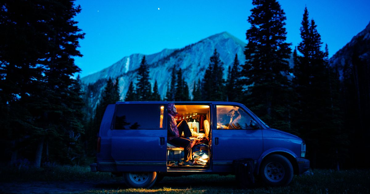 camping van parked at night with a person inside